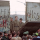 FILE - In this Nov. 11, 1989 file photo, East German border guards are seen through a gap in the Berlin wall after demonstrators pulled down a segment of the wall at Brandenburg gate, Berlin. The Berlin Wall is gone, but people can still tag their memories upon it online. The Berlin Twitter Wall, which went online Tuesday, Oct. 20, 2009 encourages people to share their memories of the wall's collapse and hopes for the future on a scrolling wall using Twitter, the social networking site.
